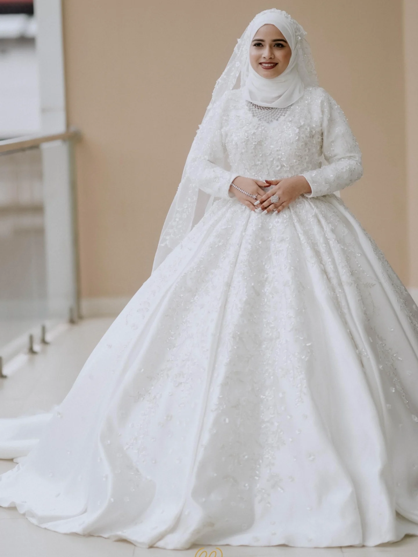 Muslim bride in a white gown and matching hijab veil