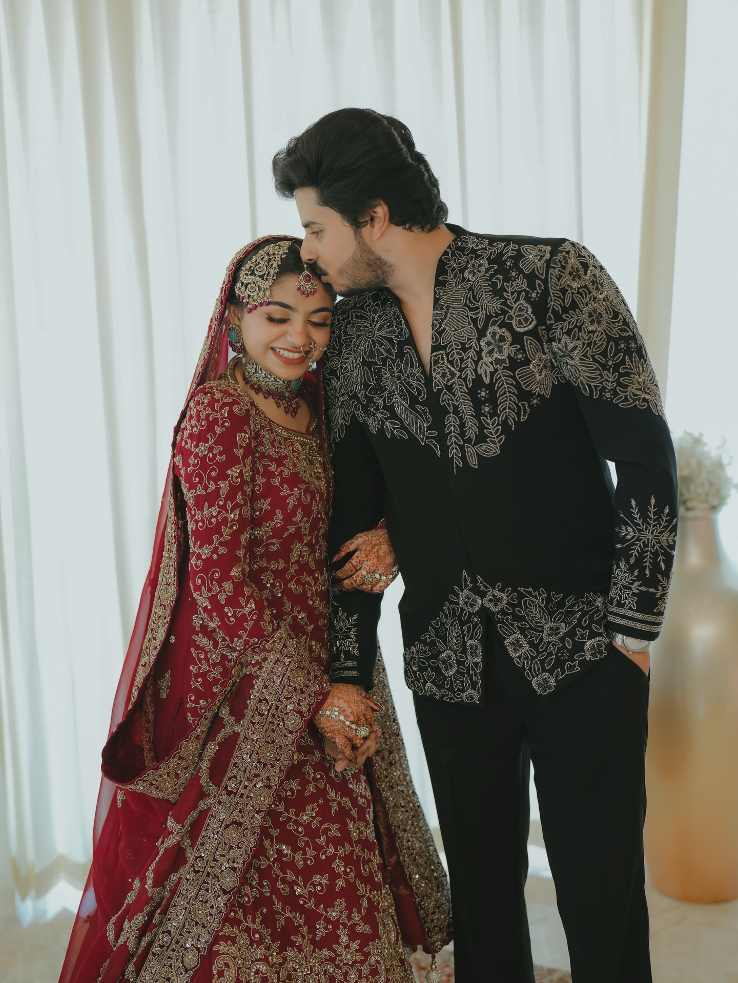 Groom in embroidered black sherwani with bride