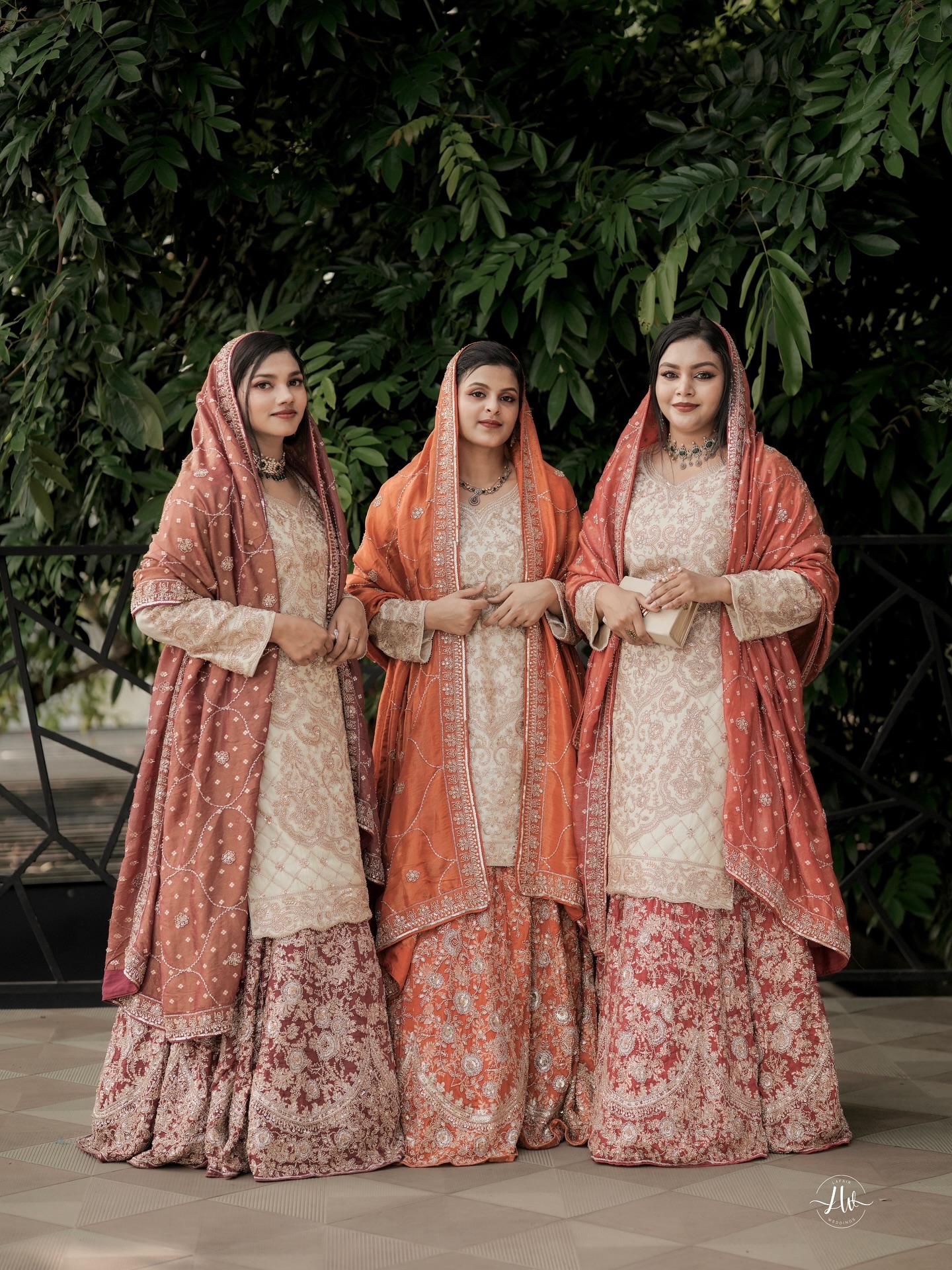 Three sisters in coordinated coral and gold Allura wardrobes